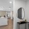 mirror hangs on wall over hallway table