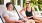 A man and a woman on lounge chairs next to a pool smiling
