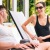 A man and a woman on lounge chairs next to a pool smiling