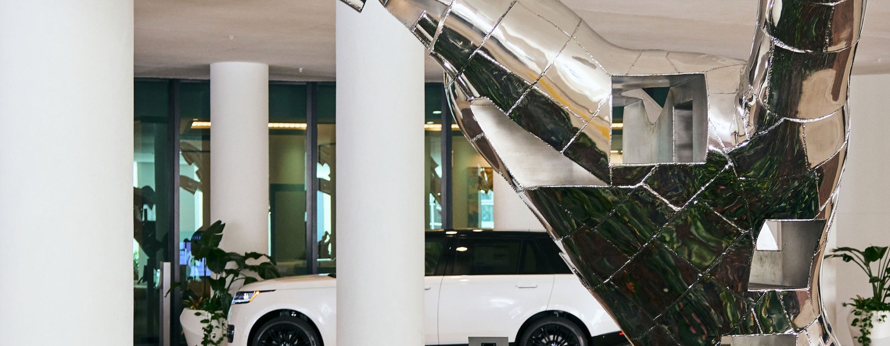 An Image of a Hand Sculpture with a Car in the background