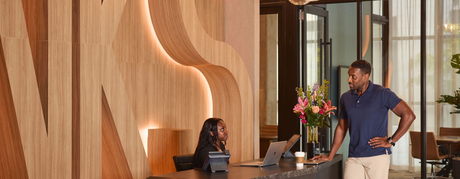 Man Speaking with Team Member at Front Desk