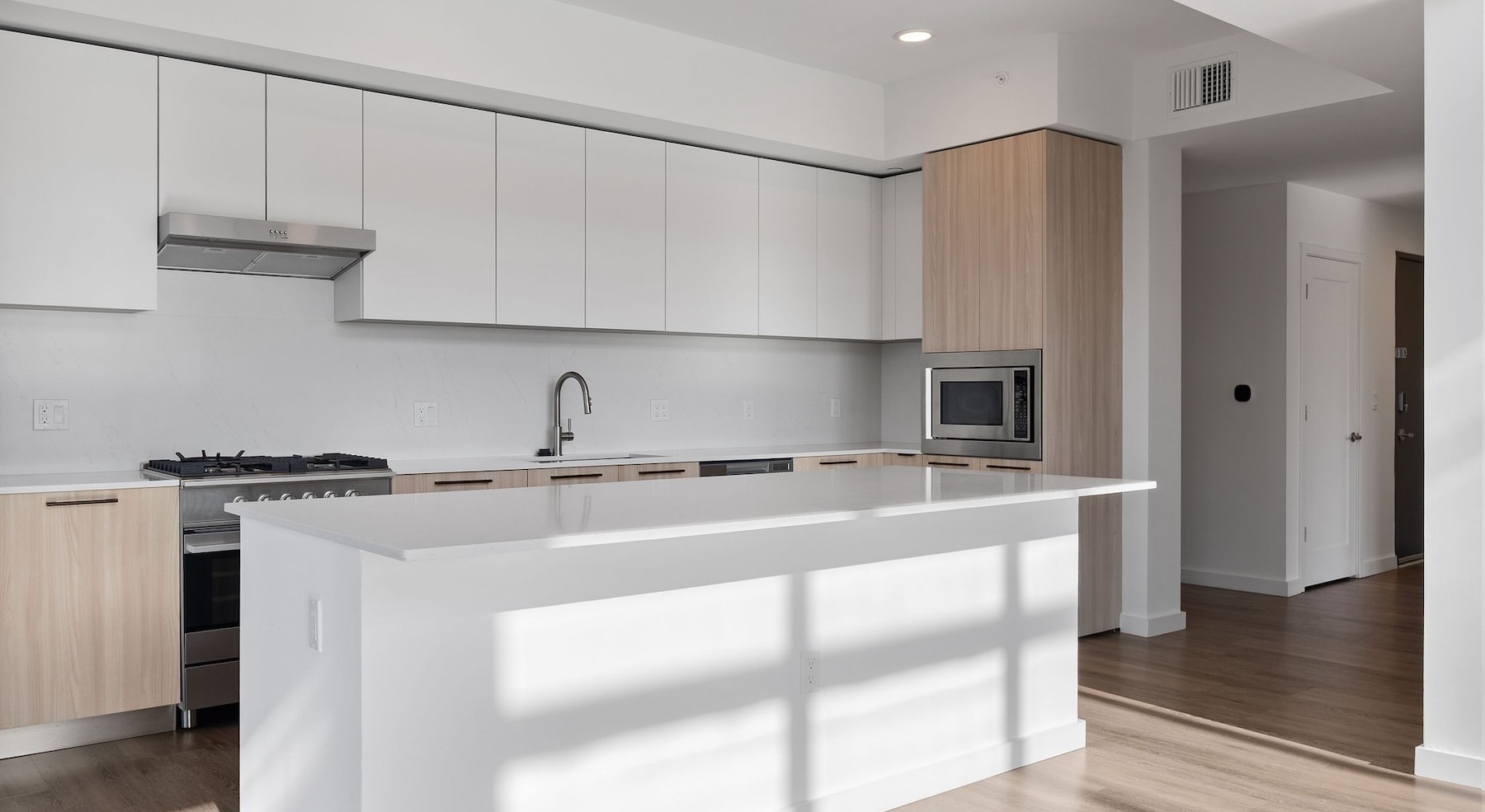a kitchen with white and wood cabinets