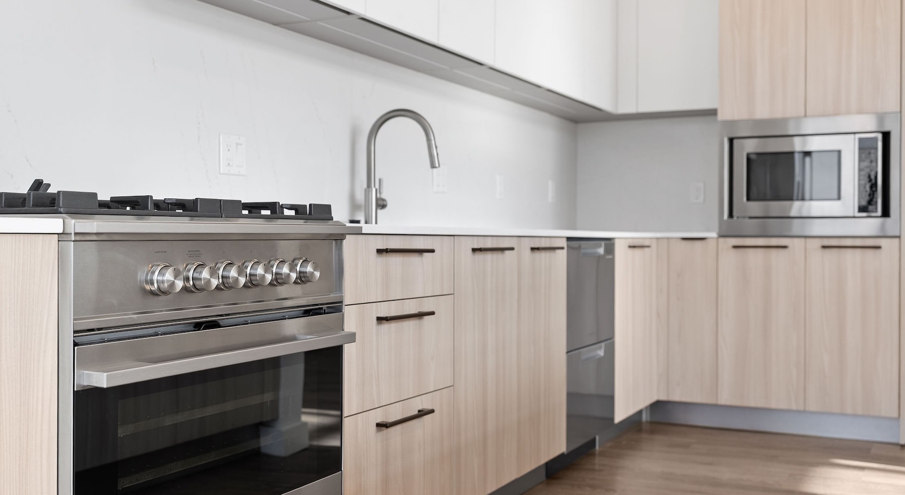 a kitchen with white and wood cabinets