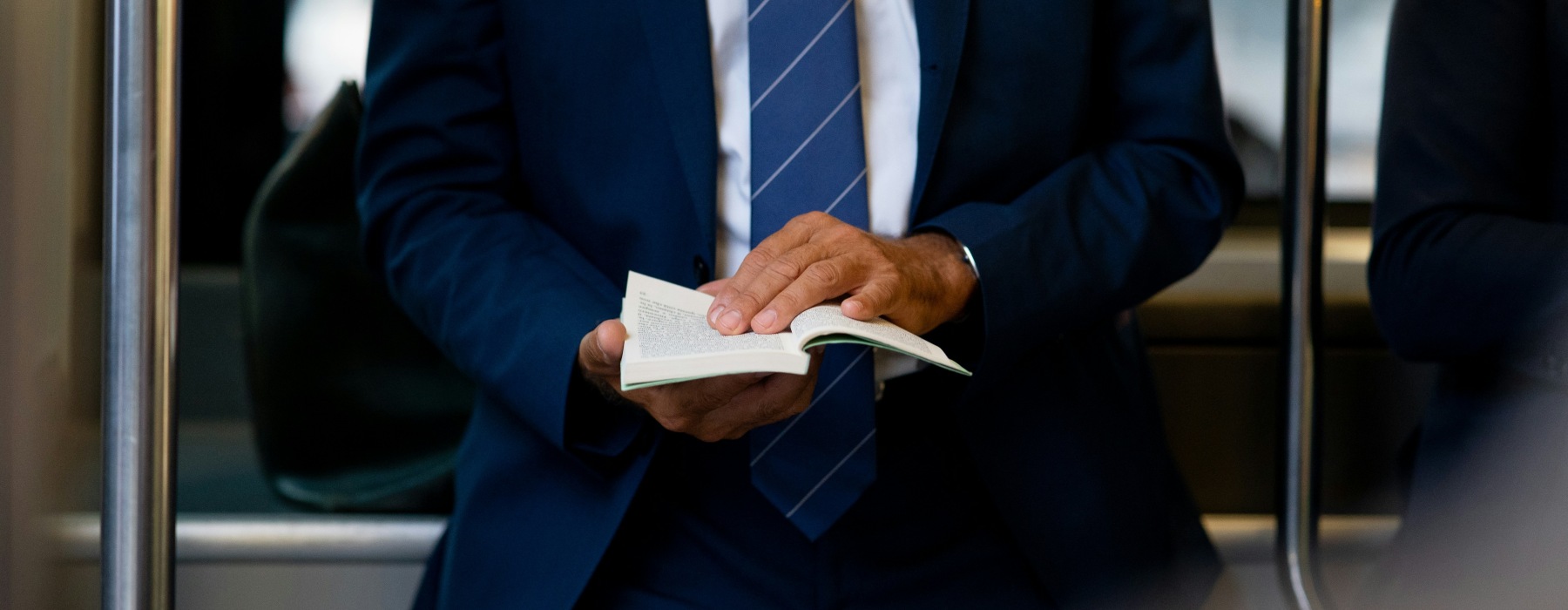 Image of Gentleman in Blue Suit with Blue Tie Holding a Notebook